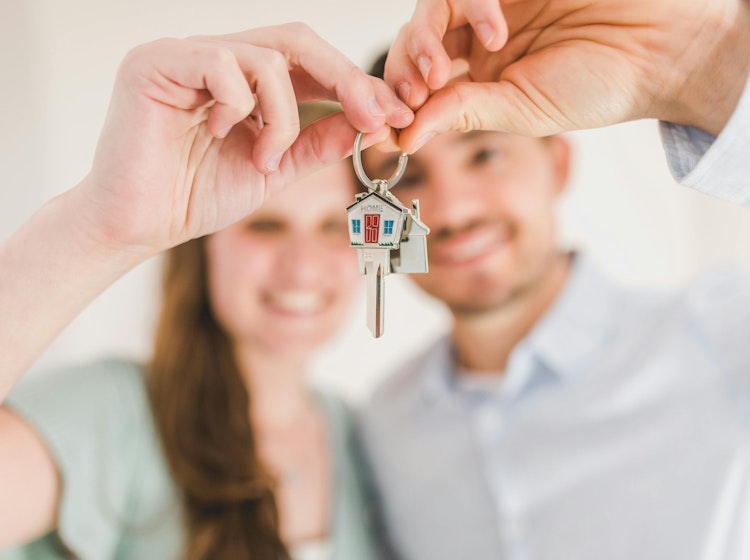 people holding keys with home keychain