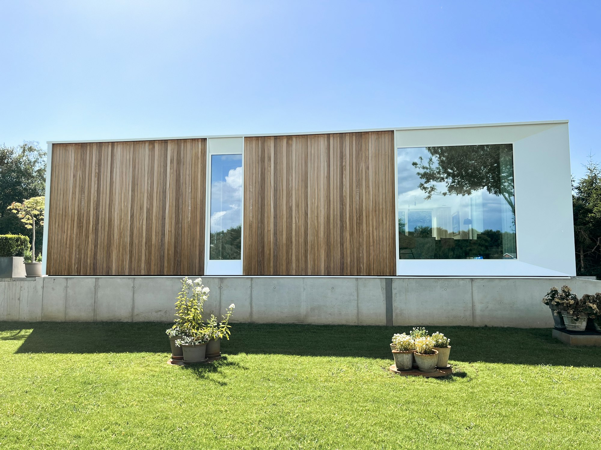 Prefab houtskeletbouw woning #144 van Skilpod. Afwerking in natuurhout en witte ramen.