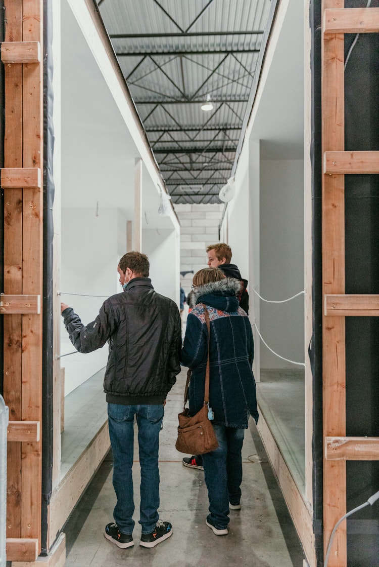 Mensen bekijken Skilpods in opbouw tijdens een open atelier
