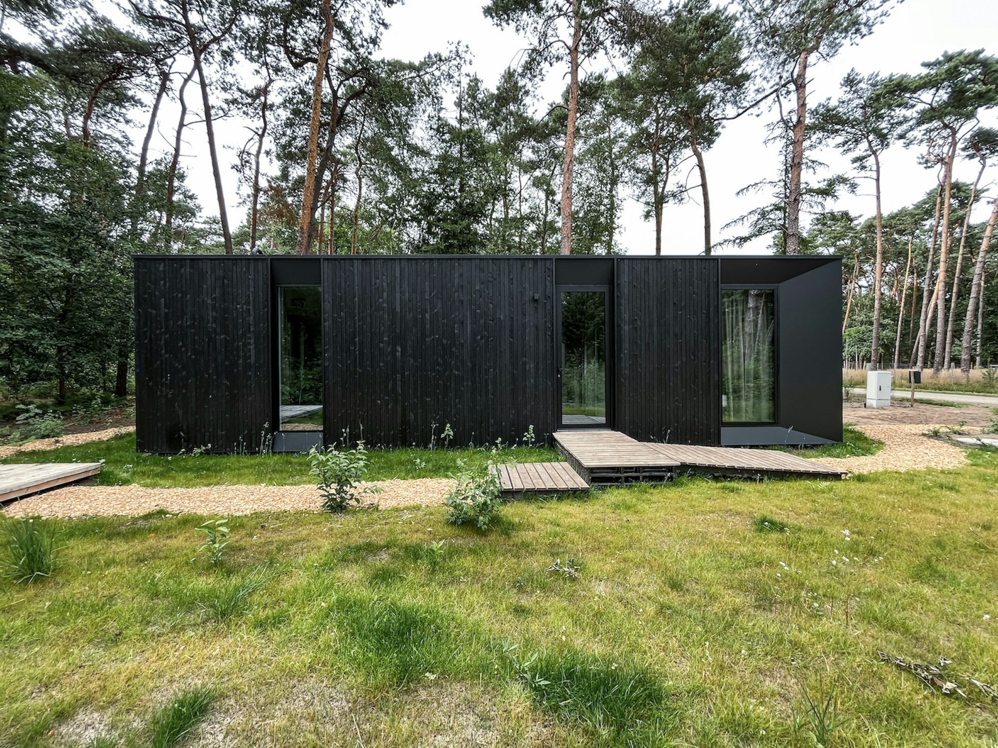 Prefab houtskeletbouw vakantiewoning prototype #80A van Skilpod. Afwerking in zwart hout en zwarte ramen.